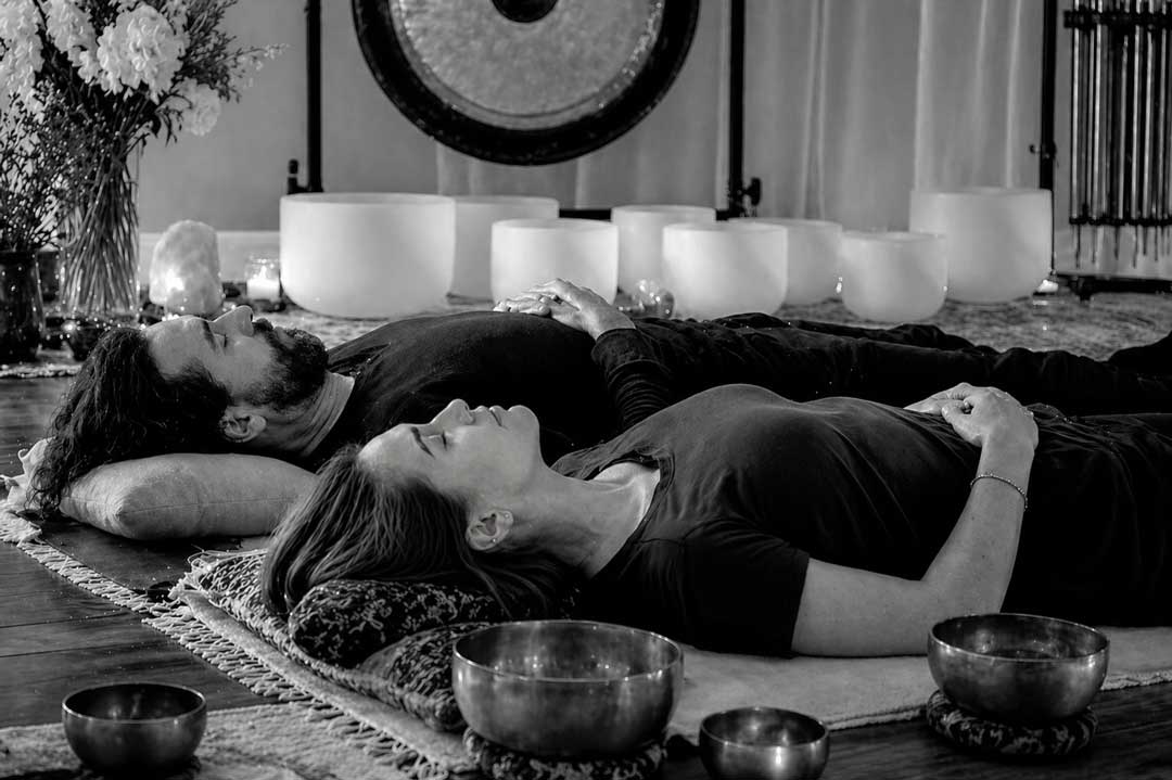 A couple laying down enjoying a soundbath.